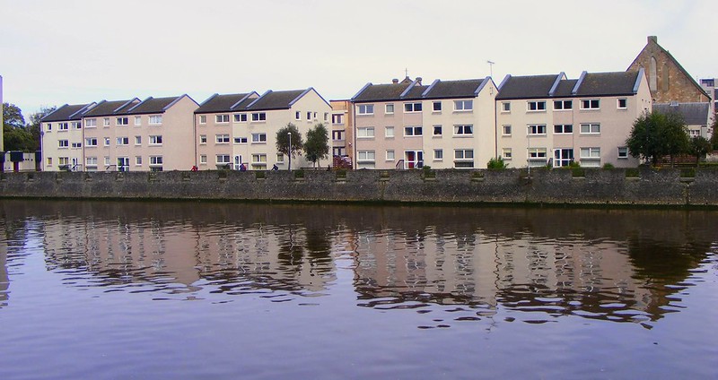 A line of white and cream houses along a river in Ayr.